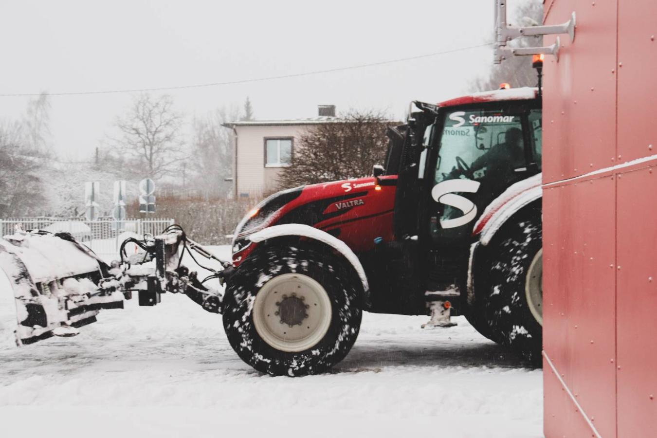 Mehhaniseeritud lumekoristus punase Valtra traktoriga